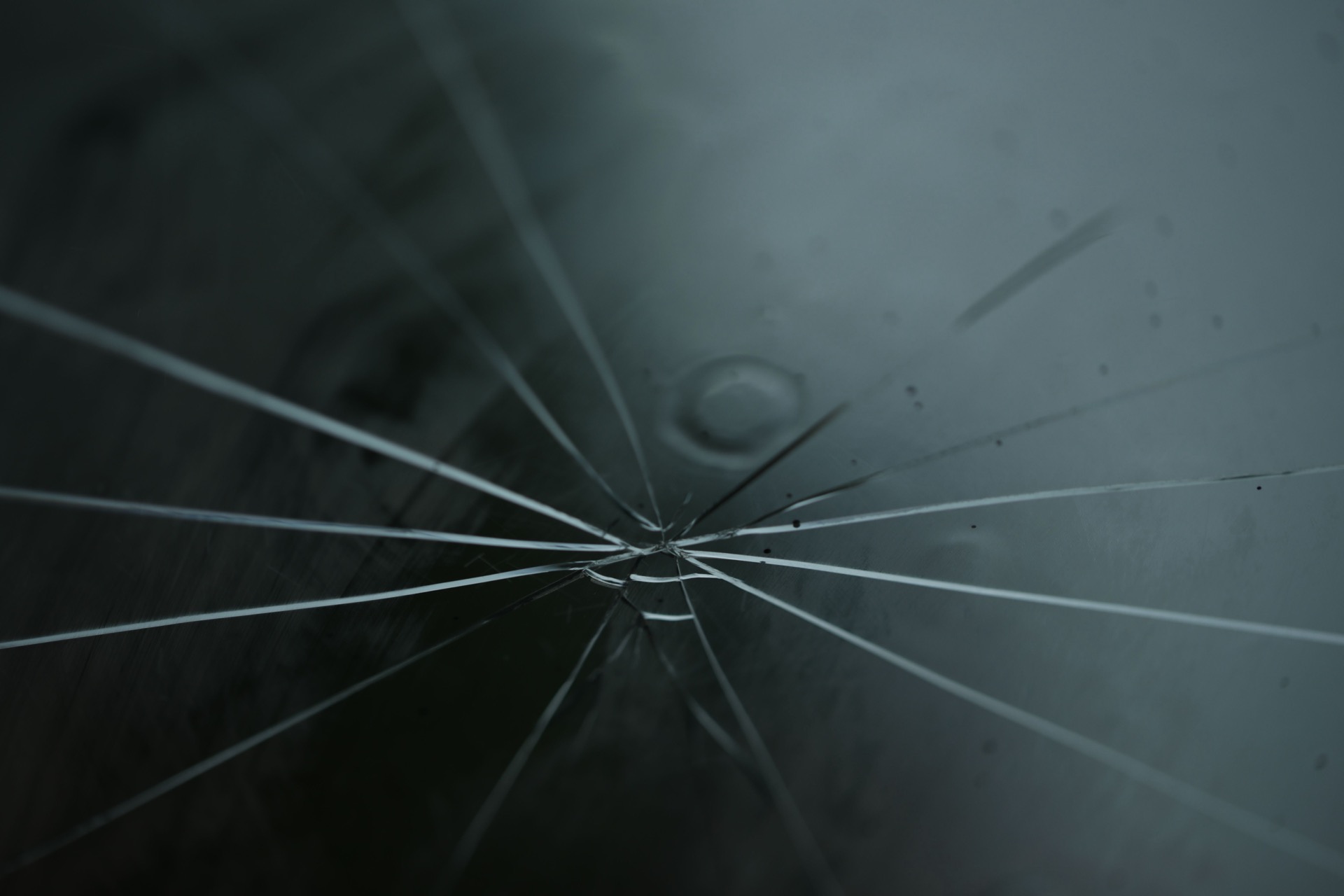 A star-shaped stone-chip crack radiating across a car windshield